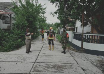 Babinsa dari Kodim 0819/Pasuruan saat melakukan penyemprotan disinfektan untuk tekan angka persebaran wabah COVID-19. (Foto: Dokumen)