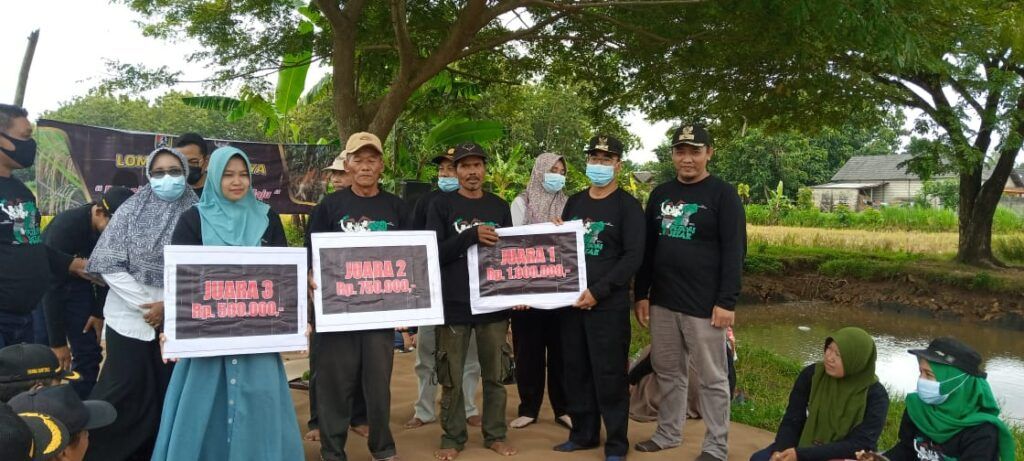 Camat Montong Suwoto menyerahkan hadiah secara simbolis kepada para pemenang Lomba Panen Raya. (Foto: Rochim/Tugu Jatim)