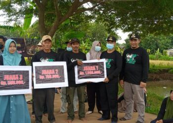Camat Montong Suwoto menyerahkan hadiah secara simbolis kepada para pemenang Lomba Panen Raya. (Foto: Rochim/Tugu Jatim)