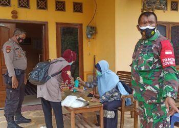 Babinsa dan Dinas Kesehatan Pandaan, Pasuruan, bekerja sama untuk men-tracing warga terkonfirmasi Covid-19. (Foto: Dok/Tugu Jatim)