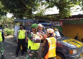 Babinsa Pasuruan melaksanakan operasi masker kepada warga. (Foto:Dok/Tugu Jatim)