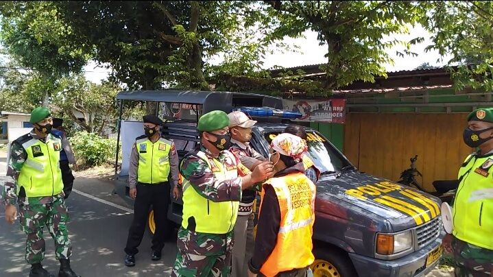 Babinsa Pasuruan melaksanakan operasi masker kepada warga. (Foto:Dok/Tugu Jatim)