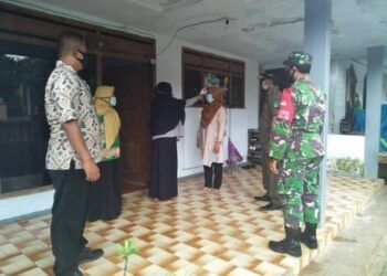 Babinsa Pasuruan mendampingi petugas Puskesmas Lumbang untuk melakukan tracing. (Foto:Dok/Tugu Jatim)