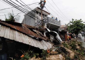 Pohon waru di daerah Mergan, Kota Malang, menimpa atap bengkel warga karena hujan deras dan angin kencang. (Foto: Azmy/Tugu Jatim)