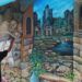 Adyanos, seniman mural Kota Malang tengah menyelesaikan lukisan mural berikon kuda di kawasan bantaran sungai Kayutangan Heritage. (Foto: Azmy/Tugu Jatim)
