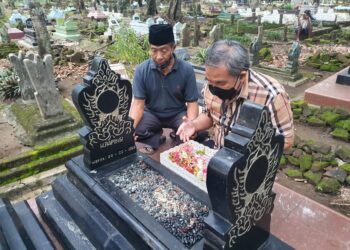 Pakar Komunikasi dan Motivator Nasional Dr Aqua Dwipayana didampingi Chudori di makam almarhum Rapingi.(Foto:Dok/Tugu Jatim)