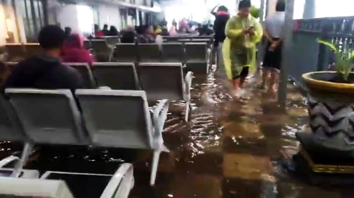 Stasiun Malang Banjir, Ruang Tunggu Penumpang Tergenang Air 5 Penumpang KA di Stasiun Kota Baru Malang tetap setia menunggu di ruang tunggu meski banjir menggenang hingga setengah lutut orang dewasa pada Minggu (14/3/2021). (Foto: tangkapan layar)