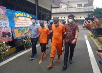 AP (kiri) dan rekannya adalah tersangka perampokan dan pembunuhan pengusaha ATK di Kabupaten Malang. (Foto: Rap/Tugu Jatim)