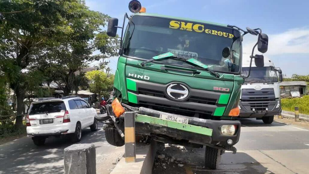 Truk trailer tabrak pembatas jalan karena sopir mengantuk. (Foto: Humas Polres Tuban/Tugu Jatim)