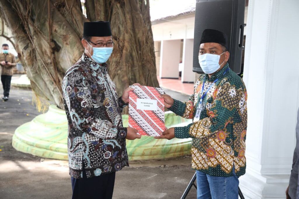 Bupati Tuban, H. Fathul Huda menyerahkan dana hibah kepada perwakilan dari Ormas NU Tuban, dan beberapa Ponpes serta TPQ lainnya. (Foto: Humas Pemkab Tuban) tugu jatim