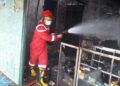 Petugas pemadam kebakaran Kabupaten Tuban berusaha memadamkan api yang melahap bangunan toko di Kecamatan Grabagan, Kabupaten Tuban, Selasa (9/3/2021). (Foto: Humas BPDB Tuban)