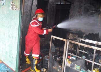 Petugas pemadam kebakaran Kabupaten Tuban berusaha memadamkan api yang melahap bangunan toko di Kecamatan Grabagan, Kabupaten Tuban, Selasa (9/3/2021). (Foto: Humas BPDB Tuban)
