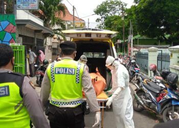 Petugas medis dan kepolisian saat proses evakuasi jenazah korban yang diduga bunuh diri di Tuban. Kini jenazah telah dievakuasi ke rumah sakit untuk dilakukan autopsi. (Foto: Moch Abdurrochim/Tugu Jatim)