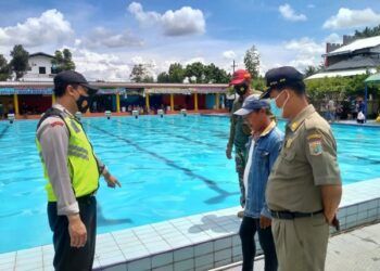 Petugas kepolisian memeriksa keadaan Kolam Renang Cerme, Desa Kendalpayak, Kabupaten Malang usai seorang bocah berusia 5 tahun tewas tenggelam, Senin (15/3/2021). (Foto: Dokumen/Polsek Pakisaji)