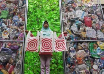 Aeshnina Azzahra Aqilani selaku Co-Captain River Warrior Indonesia berswafoto di depan sampah plastik dari Amerika Serikat. (Foto: River Warrior Indonesia)