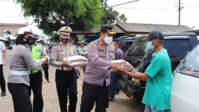 Kapolres Batu AKBP Catur C. Wibowo memberikan bantuan sembako kepada masyarakat di pasar. (Foto: Sholeh/Tugu Jatim)