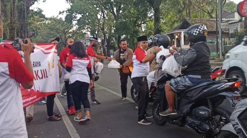 Para pengendara diberi makanan gratis oleh relawan Lumbung Informasi Rakyat (LIRA) Malang Raya. (Foto: Azmy/Tugu Jatim)