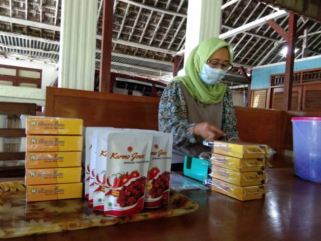 Endah sedang mengemas Kurmo Jowo, manisan buah tomat di Desa Mojodeso, Kecamatan Kapas, Kabupaten Bojonegoro. (Foto: Mila Arinda/Tugu Jatim)