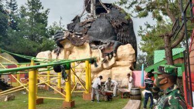 Petugas mengevakuasi reruntuhan patung gorila dengan pengamanan aparat TNI. (Foto: Sholeh/Tugu Jatim)