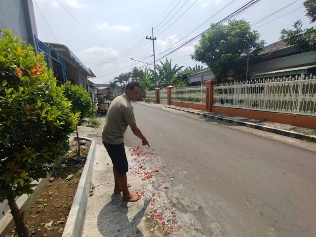 Saksi warga sekitar, Faisol (49) menunjukkan lokasi kejadian yang sudah ditabur bunga, Selasa (27/4/2021). (Foto: M Ulul Azmy/Tugu Malang/Tugu Jatim)