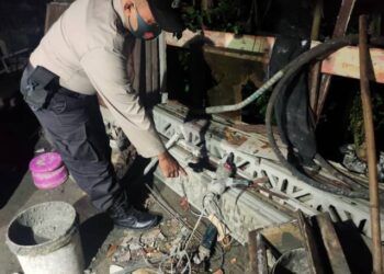 Petugas kepolisian menunjukkan saluran listrik yang diduga telah menyengat tubuh korban JA (47), warga Bojonegoro, Sabtu (3/4/2021) malam. (Foto: Dokumen/Polsek Sumberrejo)