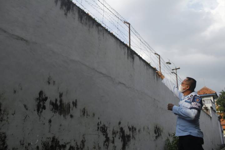 Petugas Lapas Kediri menjelaskan jika bungkusan plastik berisi pil berlogo palu arit tersangkut di tembok lapas. (Foto: Rino Hayyu Setyo/Tugu Jatim)