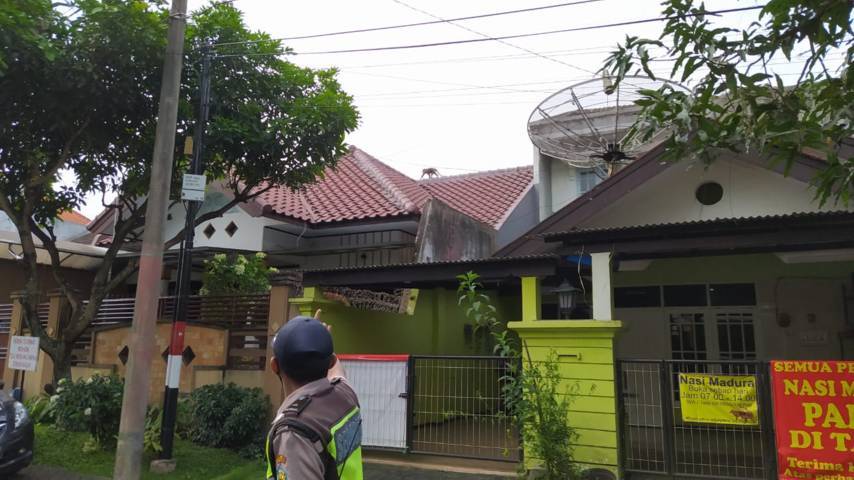 Siswanto, Satpam Perum Araya Blok M menunjukkan seekot monyet yang sedang berkeliaran di atap rumah warga, Minggu (14/4/2021). (Foto: M Ulul Azmy/Tugu Malang/Tugu Jatim)