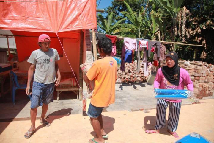 Warga turut membantu tim Tugu Media Group ketika menyalurkan bantuan pada korban gempa di Dampit, Malang, Selasa (27/4/2021). (Foto: Bayu Eka/Tugu Malang/Tugu Jatim)