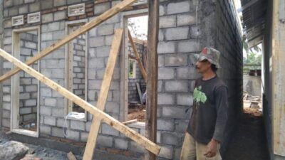 Iswahyudi saat ikut membantu pembangunan rumahnya. (Foto: Rap/Tugu Jatim)