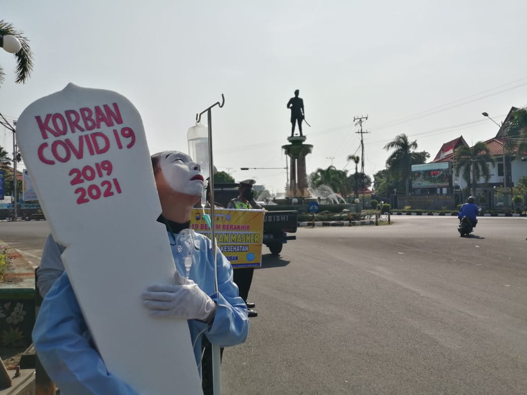 Petugas Polres Tuban melakukan aksi treatrikal untuk sosialisasi bahaya virus Covid-19. (Foto: Rochim/Tugu Jatim)