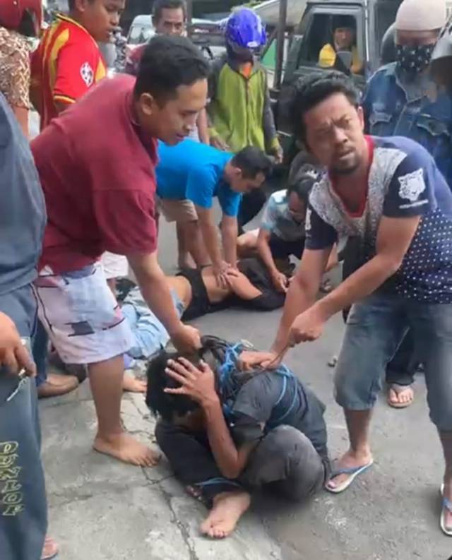 Pelaku pencurian burung di Jalan Teluk Grajakan, Kecamatan Blimbing, Kota Malang, diamuk massa karena diduga menusuk salah seorang warga Sabtu (29/05/2021). (Foto: Tangkapan layar/Azmy/Tugu Jatim)