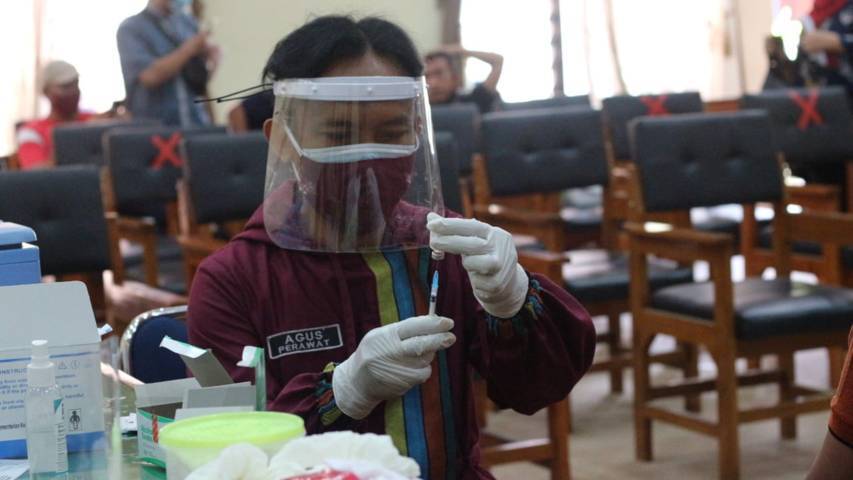 Perawat menyiapkan vaksin untuk warga. (Foto: Zamz/Tugu Jatim)