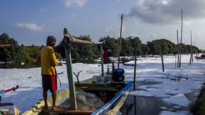 Pemandangan yang miris saat warga mencari ikan di tengah gunungan busa limbah mikroplastik di sungai Tambak Wedi, Jumat (28/05/2021). (Foto: Rangga Aji/Tugu Jatim)