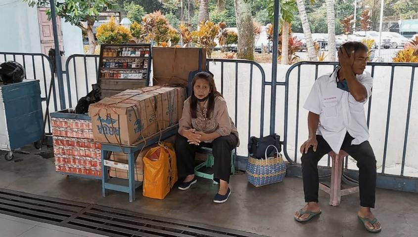 Diah Wilujeng, seorang pedagang rokok di Terminal Arjosari, yang tetap semangat berjualan meski sepi aktivitas di terminal. (Foto: Azmy/Tugu Jatim)