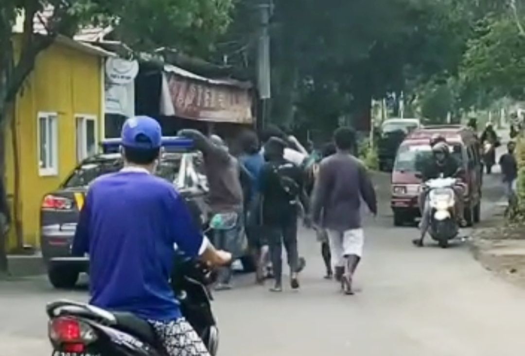 Saling Lempar Batu, 2 Kelompok Mahasiswa Papua di Malang Bentrok! 4 Massa aksi menggebrak mobil polisi. (Foto:tangkapan layar video)