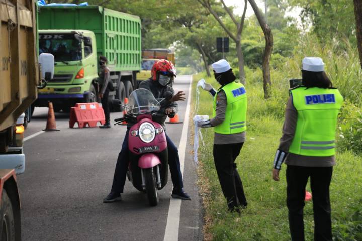 Srikandi Polda Jatim membagikan masker dan sembako berupa beras di Kabupaten Bangkalan, Rabu (09/06/2021).(Foto: Polda Jatim/Tugu Jatim)