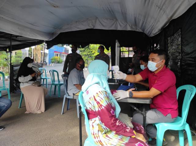 Salah satu warga Tuban dicek suhunya memakai thermo gun sebelum melaksanakan vaksinasi.(Foto: Rochim/Tugu Jatim)