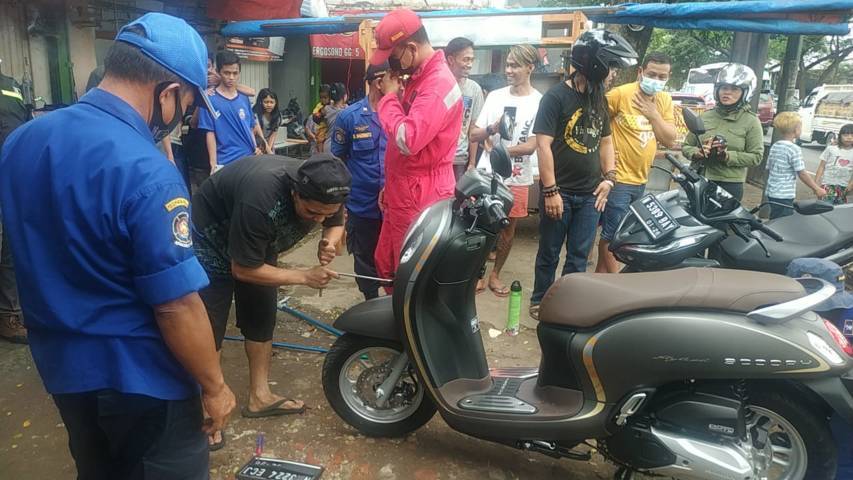 Proses evakuasi ular yang bersembunyi di dalam motor pengendara di Jalan Raya Gadang 1 A, Kota Malang, Selasa (22/06/2021). (Foto/Damkar Kota Malang/Tugu Jatim)