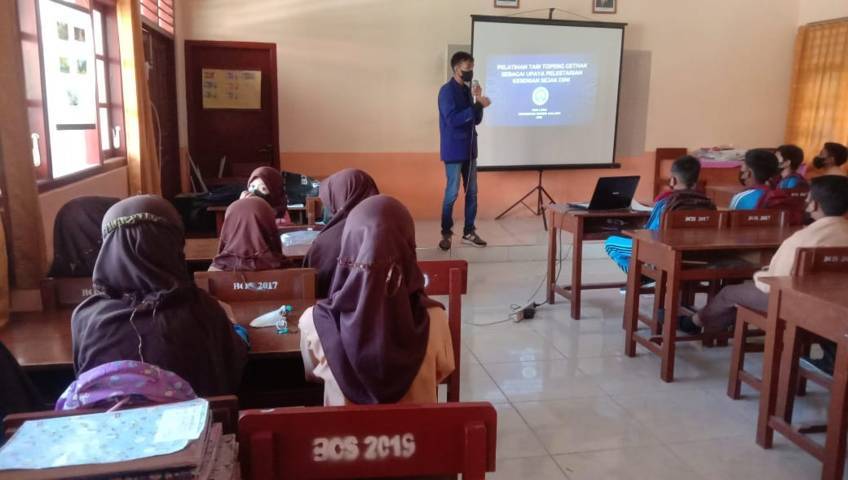 Salah satu mahasiswa KKN UM menjelaskan soal Tari Topeng Ghetak kepada siswa SDN Sumedangan 3 Pademawu. (Foto: Dokumen/Tugu Jatim)