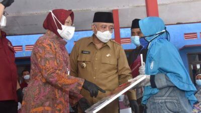 Menteri Sosial Tri Rismaharini didampingi Bupati Malang Muhammad Sanusi saat memberikan secara simbolis kartu PKH kepada warga Desa Kanigoro, Kecamatan Pagelaran, Kabupaten Malang, Selasa (29/06/2021). (Foto: Rizal/Tugu Jatim)