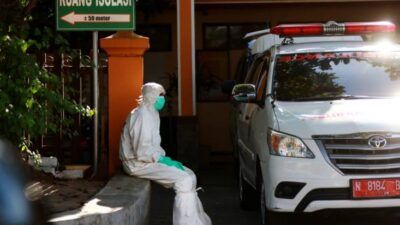 Salah satu petugas PSC 119 Dinkes Kota Malang yang tampak siaga di depan mobil ambulans. (Foto: Rubianto/Tugu Jatim)