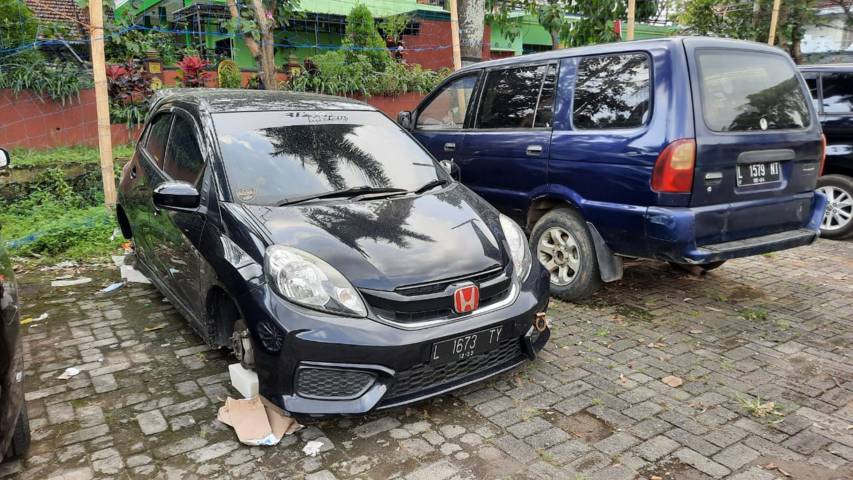 Unik! Ada Maling di Malang Spesialis Curi Ban Mobil 2 Mobil tanpa ban depan di Lapangan Merjosari, Kota Malang.(Foto:Azmy/Tugu Jatim)