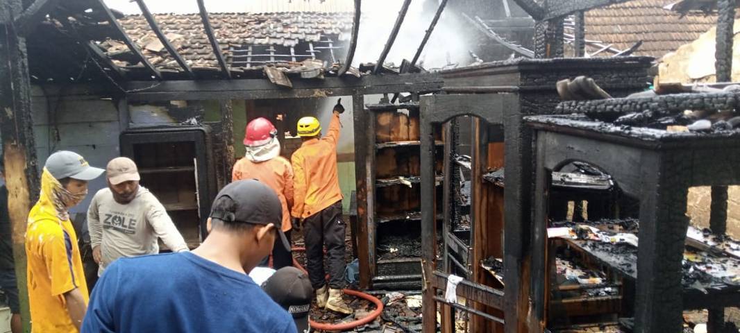 Petugas Damkar Tuban dibantu warga saat berusaha memadamkan api. (Foto: Rochim/Tugu Jatim)