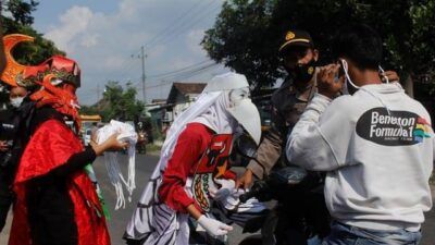 Kapolsek Puncu Polres Kediri bersama siswa SMAN 1 Puncu yang mengenakan kostum burung garuda membagikan masker kepada para pengguna jalan, Senin (31/5/2021) kemarin. (Foto: Rino Hayyu/Tugu Jatim) hari lahir pancasila