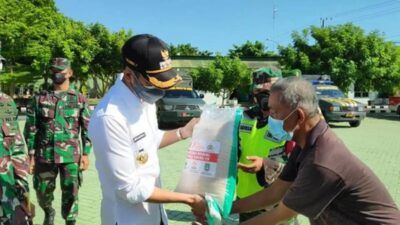 Bupati Tuban Aditya Halindra Faridzki menyerahkan bantuan beras dan masker kepada perwakilan masyarakat di Makodim 0811 Tuban. (Foto: Rochim/Tugu Jatim)