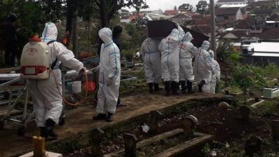 Petugas pemulasaraan di Kota Batu tampak memakamkan pasien Covid-19 secara protokol kesehatan. (Foto: Sholeh/Tugu Jatim)