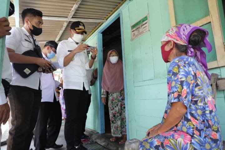 Bupati Tuban Aditya Halindra Faridzky mengecek kartu bansos salah satu KPM di Kecamatan Plumpang, Rabu (28/07/2021). (Foto: Humas Pemkab Tuban/Tugu Jatim)