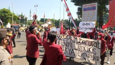 Anggota Ikatan Mahasiswa Muhammad (IMM) Tuban menggelar aksi di depan Gedung Pemkab Tuban, Kamis (12/08/2021) untuk menuntut PPKM dievaluasi dan dikaji ulang. (Foto: Rochim/Tugu Jatim)