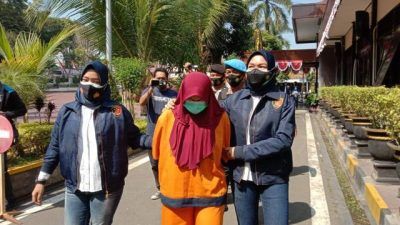 Petugas kepolisian membawa PTH, tersangka penggelapan dana PKH di Desa Kanigoro, Kecamatan Pagelaran, Kabupaten Malang, Senin (16/08/2021). (Foto: M. Sholeh/Tugu Jatim)