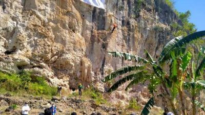 Anggota Mapala Guyub dan atlet panjat tebing di Tuban mengibarkan bendera Merah Putih di Puncak Tebing Sumur Pahit Semanding untuk memperingati HUT RI ke-76 pada Selasa (17/08/2021). (Foto: Mochamad Abdurrochim/Tugu Jatim)